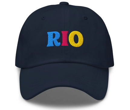 Casquette bleu marine avec le texte 'RIO' brodé en lettres colorées bleu, rouge et jaune, évoquant l'énergie, les couleurs des carnavals brésiliens et l'ambiance festive de Rio de Janeiro. Accessoire authentique inspiré de la culture brésilienne.