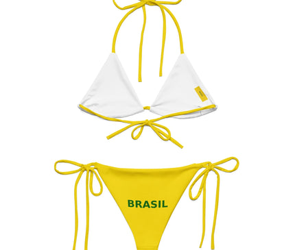 Bikini brésilien jaune et blanc avec haut minimaliste en triangle et bas à lacets, portant l'inscription 'Brasil' en vert sur la culotte, évoquant les plages emblématiques de Copacabana et Ipanema, et inspiré par l'énergie festive et la culture du Brésil.