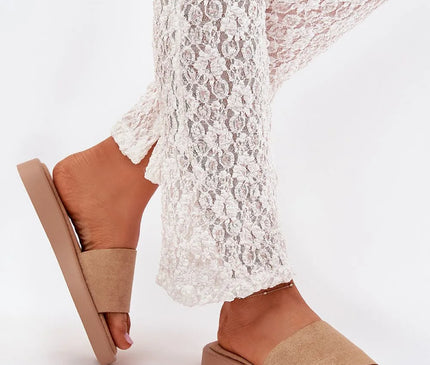 Sandales minimalistes beiges pour femme, en matières légères et confortables, inspirées du style décontracté et de la culture brésilienne. Idéales pour un look estival, associées à un pantalon en dentelle blanche.