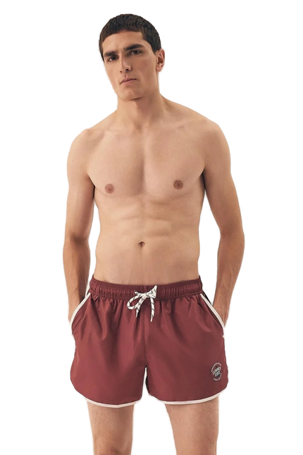 Short de bain pour homme couleur bordeaux à taille élastique avec cordon blanc, inspiré de l’énergie décontractée et vibrante du littoral brésilien. Coupe courte, détails modernes et esprit estival, parfait pour la plage ou les journées chaudes d'été.