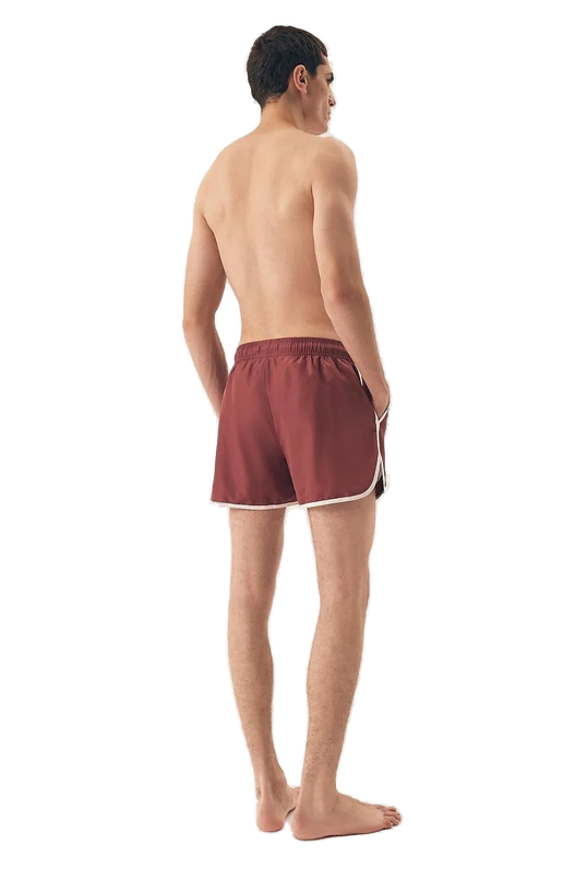 Short de bain homme de couleur bordeaux avec bordures blanches, inspiré par l'énergie et le style décontracté du littoral brésilien, idéal pour des journées ensoleillées à la plage comme à Copacabana. Confortable, moderne et polyvalent, conçu pour l'élégance estivale et le dynamisme tropical.