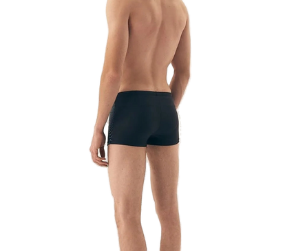 Homme portant un maillot de bain moderne et minimaliste noir, inspiré de l'élégance décontractée des plages brésiliennes telles que Copacabana et Ipanema, mettant en valeur le confort et le style.