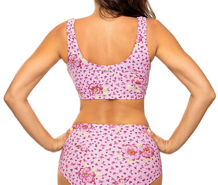 Maillot de bain deux pièces rose à motif floral, style sportif, composé d'un haut élastique sans baleines à dos couvrant et d'un slip taille haute, fabriqué en tissu italien Carvico Tessuti, mettant en valeur le bronzage.