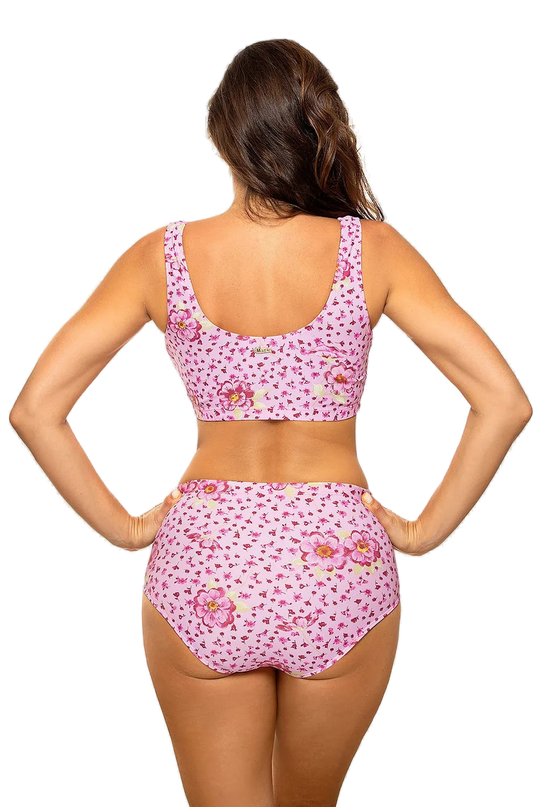Maillot de bain deux pièces rose à motif floral, style sportif, composé d'un haut élastique sans baleines à dos couvrant et d'un slip taille haute, fabriqué en tissu italien Carvico Tessuti, mettant en valeur le bronzage.